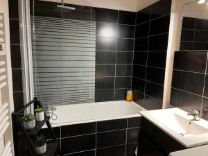 a bathroom with a bath tub and a sink at La Villa Louana 2 Charme de l'ancien au cœur de ville in Aubusson +34 photos