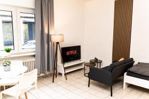 a living room with a couch and a tv at CosyHomes24 - Centrally with parking space - HA01 in Hagen