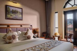 Postel nebo postele na pokoji v ubytování Canvas Sapa Legend Hotel