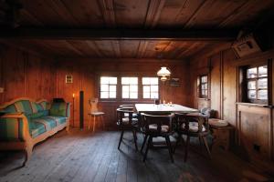 Chalets Casa da Luzi في Surcasti: غرفة مع طاولة وكراسي وأريكة