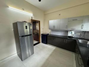 a kitchen with a stainless steel refrigerator and a sink at Family fun 2 BHK spacious house in Trivandrum