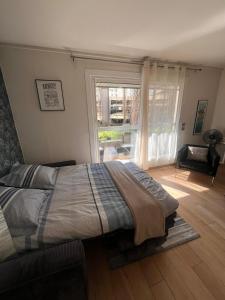a bedroom with a bed and a large window at Chez Elea - Au cœur d'Annecy & à deux pas du lac in Annecy