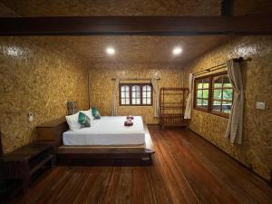 a bedroom with a bed in the middle of a room at Koh Jum Hillside Resort in Ban Ko Phrao
