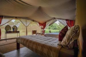 a bedroom with a bed in a tent at Dolly Farm & River Camp, Luxury Tents in Usa River
