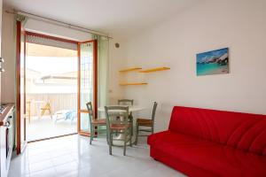 a living room with a red couch and a table at On the Beach in Tortoreto Lido