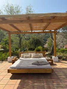 皮萨拉Santa Teresa Bed & Breakfast Andalusien的天井上木凉棚下的一张床位