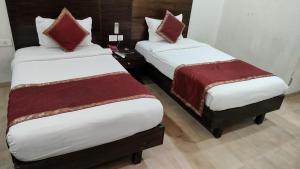 two twin beds in a hotel room with sidx sidx sidx sidx at 66 Residencey in Jaipur +43 photos