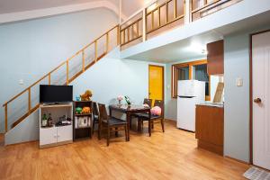 a living room with a dining room table and a staircase at hongcheon river view sonamu pension in Hongcheon