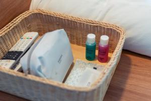 a wicker basket with remotes and bottles on a table at Geojae Mins Pension in Geoje