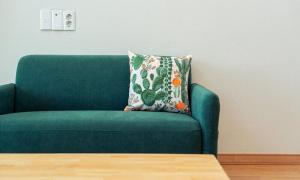 1 sofá verde con almohada en la sala de estar en Geojae Mins Pension, en Geoje