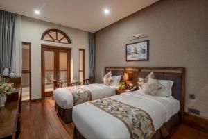 Postel nebo postele na pokoji v ubytování Canvas Sapa Legend Hotel