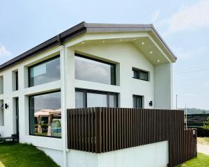 a white house with black windows and a fence at Day Off Paju in Paju