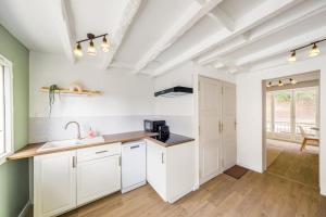 a kitchen with white cabinets and a sink at La Vie en Rose in Barentin