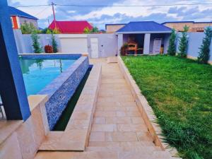 a swimming pool in the backyard of a house at Mardakan Villa in Əzizbǝyov