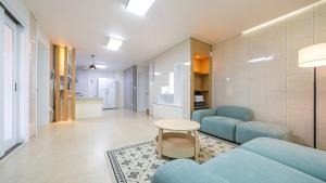 Samgŏ-riにあるGapyeong Refresh Pension Spa, Private Houseの青いソファとテーブルのあるリビングルーム
