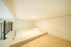 a white bedroom with a bed in the corner at Gangneung Uahaeng Stay Private House in Gangneung +8 photos