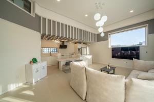 a large living room with a couch and a kitchen at Gangneung Uahaeng Stay Private House in Gangneung