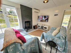 a living room with a couch and a fireplace at Old Oak Tree Cottage in Rydal