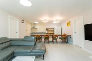 a living room with a couch and a table at Gapyeong Full Room Detached Pension in Gapyeong