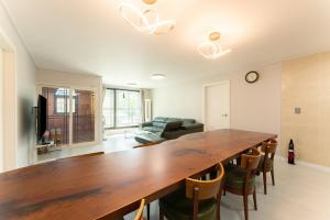 a living room with a large wooden table and chairs at Gapyeong Full Room Detached Pension in Gapyeong