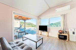 a living room with a couch and a tv at Gangneung Dawon Hill Pension in Gangneung +14 photos