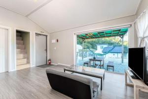 a living room with a table and a tv at Gangneung Dawon Hill Pension in Gangneung