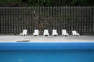 a group of white chairs sitting in front of a fence at Art City Two in Yangju