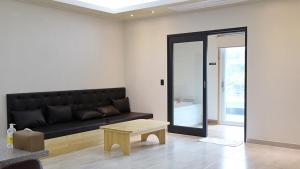 a living room with a black couch and a table at Epop Resort Building A in Chuncheon
