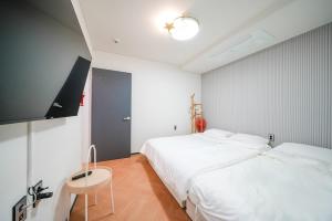 a bedroom with a white bed and a small table at GaPY Mom Stay Private Pool Villa in Gapyeong