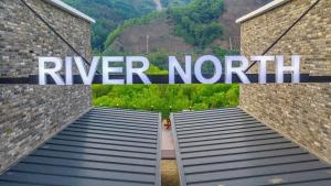 a sign that says river north on a brick wall at Chuncheon Namiseom River North Pool Villa in Witmal +15 photos