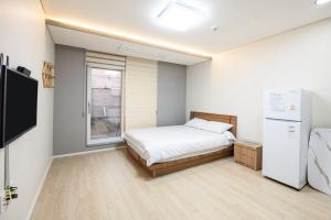 a small bedroom with a bed and a window at Yangyang Hajodae Sungsim Pension in Ka-kōtei-ri