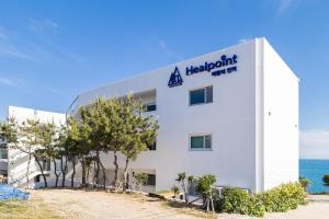 een wit gebouw met een heterotronbord erop bij Geoje Hill Point Youth Hostel in Geoje 