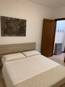 een slaapkamer met een bed en een schilderij aan de muur bij La Quiete 27 Lake view by Gardadomusmea in Tremosine Sul Garda