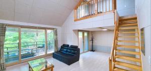 a living room with a staircase and a couch at Hwacheon 632 Pension in Hwach'ŏn
