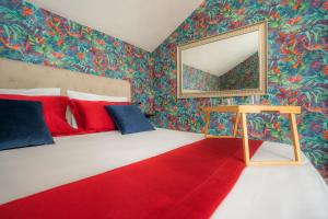 a bedroom with a bed with a mirror and a red rug at Beneduce B&B ROOMS in Santa Maria di Castellabate