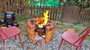 a fire pit in a yard with two red chairs at Bauhaus In Wonju in Wonju
