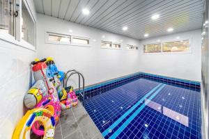 a swimming pool with a blue tiled floor and a swimming pool at Gapyeong BB Kids Pool Villa in Sŏri-gol