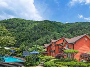 a house with a swimming pool and a mountain at Eoullim Pension - Moonlight Yard in Pyeongchang 
