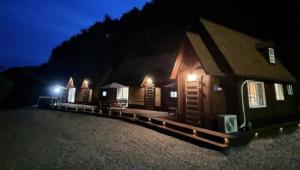 a group of small wooden buildings at night at Yanggu Byeolha Pension in Yanggu