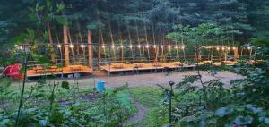 a garden with a bunch of tables and lights at Hwacheon Sintobule Pension in Hwach'ŏn