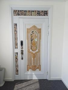 a white door with a gold knocker on it at Gangneung Nemo’s Dream Pension in Gangneung