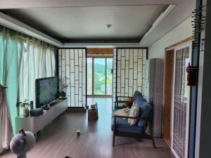 江陵市にあるGangneung Blue Fragranceのリビングルーム(青い椅子、テレビ付)