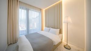 a bedroom with a white bed and a large window at Gapyeong Casabella Pool Villa in Gapyeong