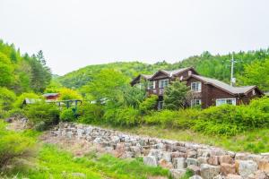 a house on a hill with a stone wall at Pyeongchang Zermatt Pension Family, Couple in Pyeongchang  +16 photos