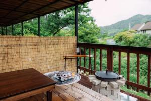 a grill on a wooden deck with a table at Gapyeong Imchori Buttumark Pension in Gapyeong