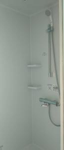 a white bathroom with a shower and a sink at 栗山さん家のアロハミエント in Shirahama