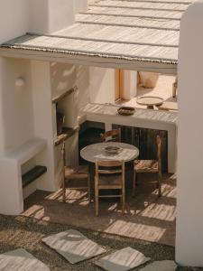 a small table and chairs in a room with a roof at The Wild by Interni in Kalafatis