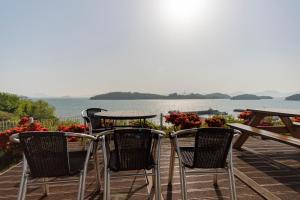 un tavolo e sedie su una terrazza con vista sull'acqua di Yeosu Gyeongdo Pension a Yeosu