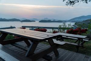 un tavolo da picnic in legno con vista sul lago di Yeosu Gyeongdo Pension a Yeosu Altre 30 foto