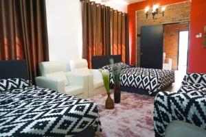 a hotel room with two beds and a couch at D Pine Villa in Bukit Tinggi